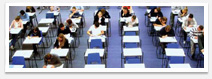 People sitting at desks in an exam hall, during an examination